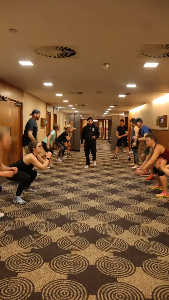 Corporate fitness participants completing a group squat circuit led by Sidhu Fitness