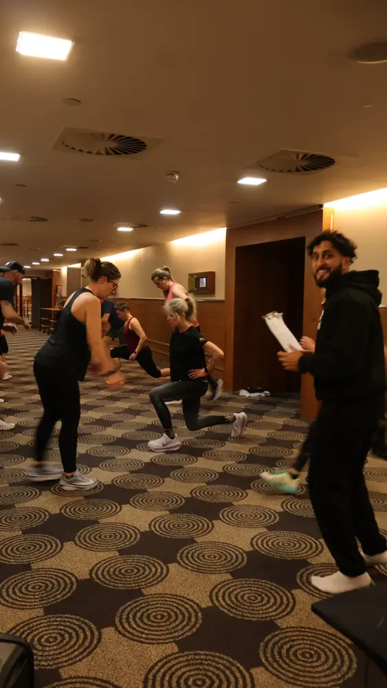 Tony Sidhu monitoring form and recording progress during a private group fitness event