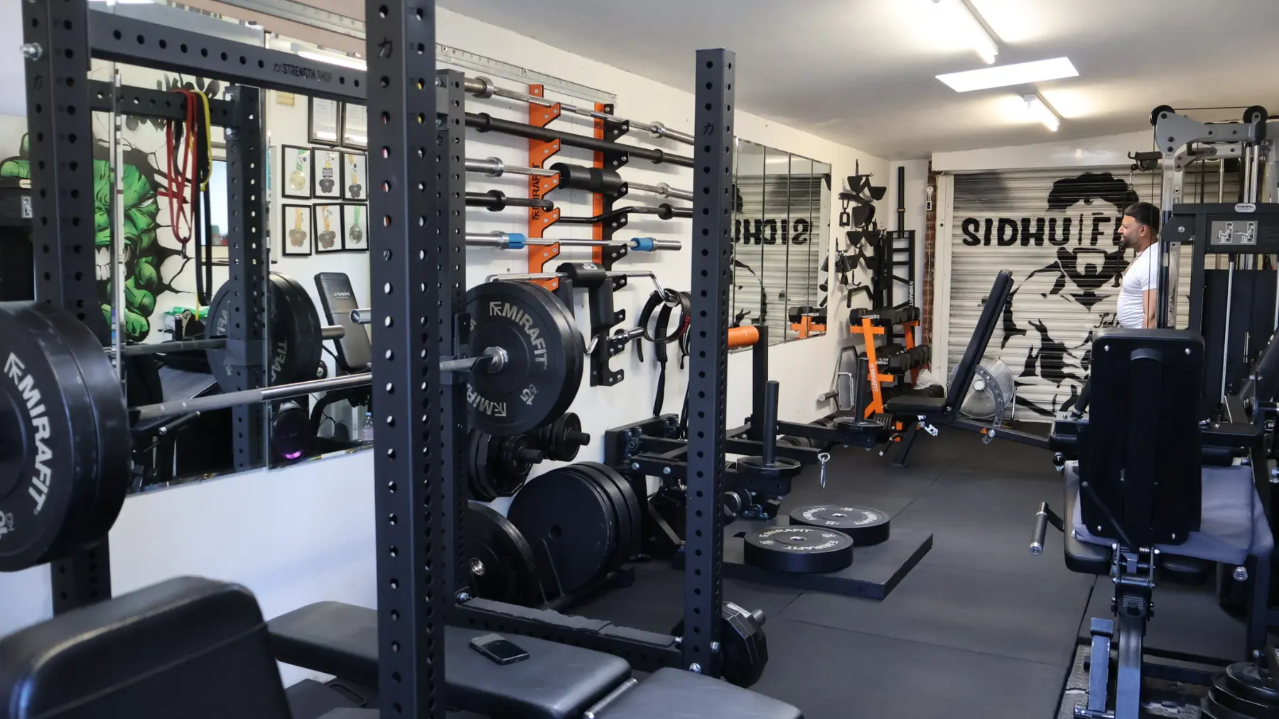 Wide view of strength equipment and free weights inside the Sidhu Fitness private gym studio