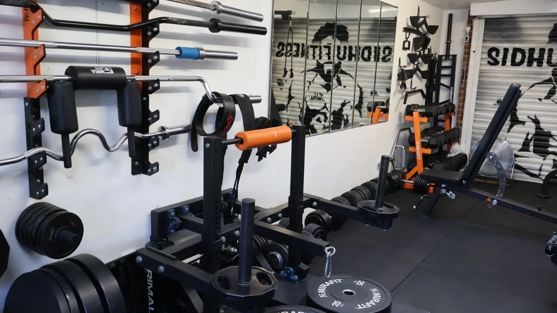 Branded barbell and strength equipment inside the Sidhu Fitness private studio