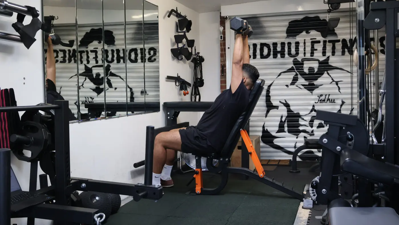 Male Sidhu Fitness client completing an upper-body strength exercise with Tony coaching