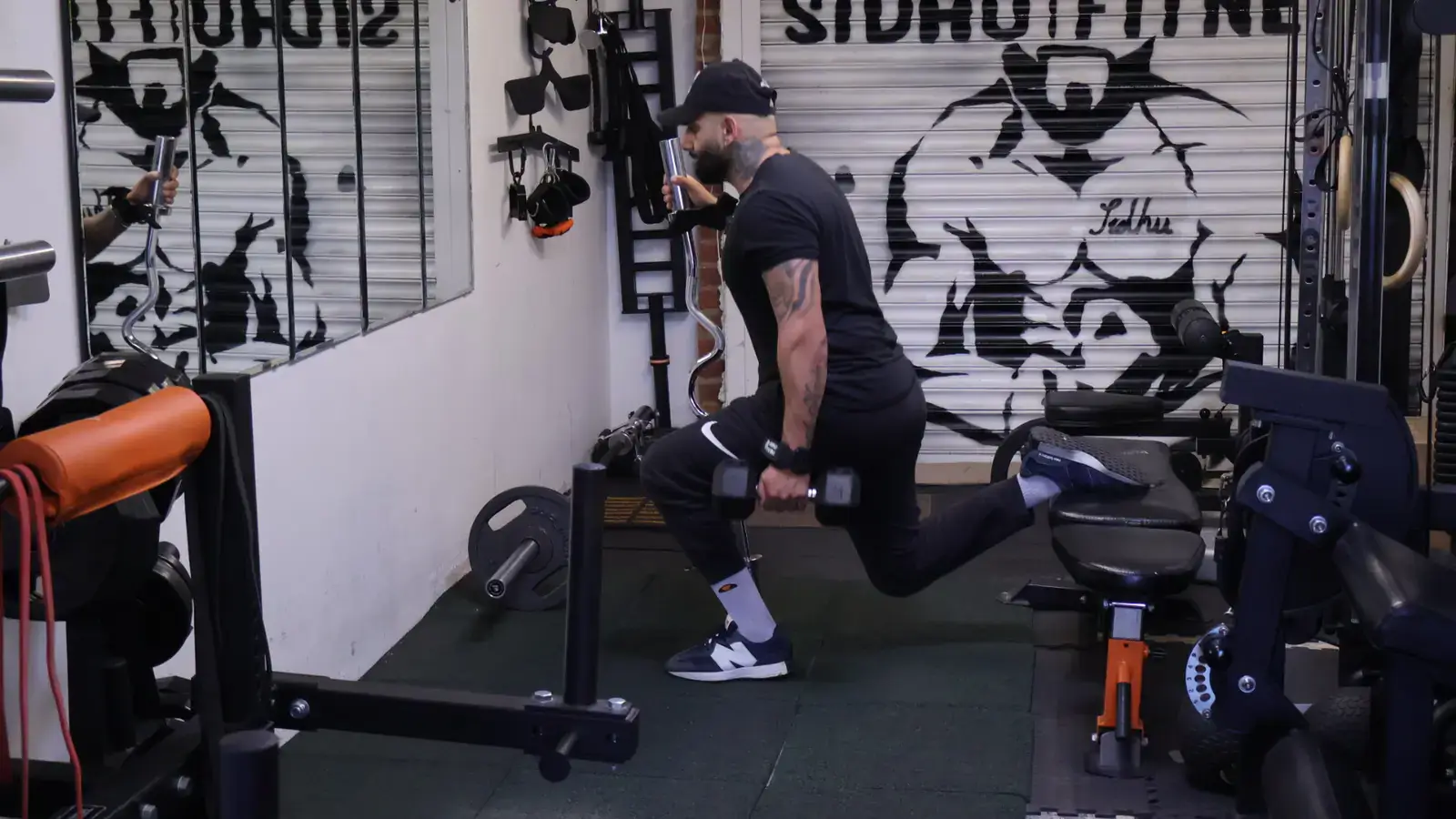 Male Sidhu Fitness client completing a dumbbell split squat in the private personal training studio