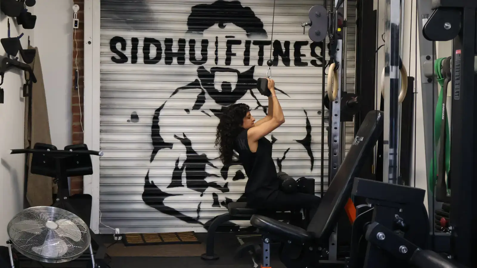 Female Sidhu Fitness client completing a cable pulldown exercise in the private Feltham studio